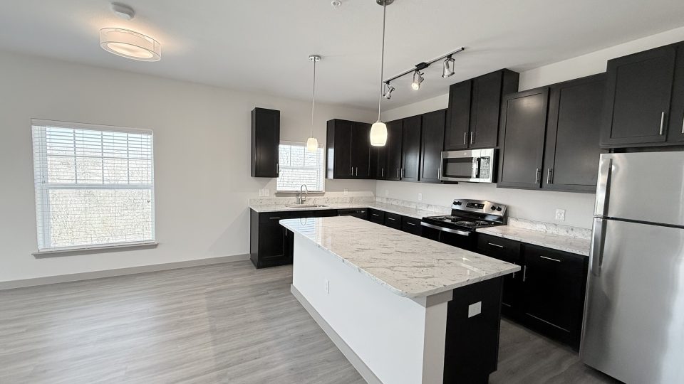 Partial kitchen and living room view with center island.