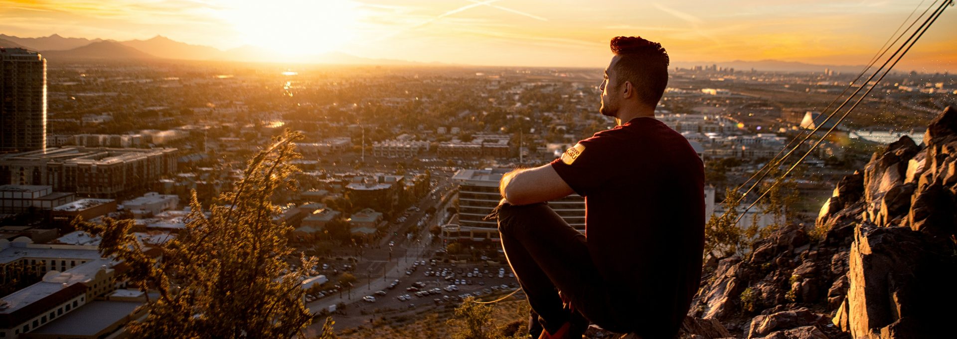 Lifestyle photo of golden hour photography of man sitting on rock