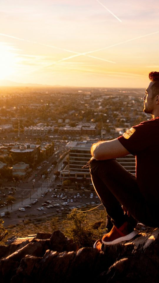 Lifestyle photo of golden hour photography of man sitting on rock