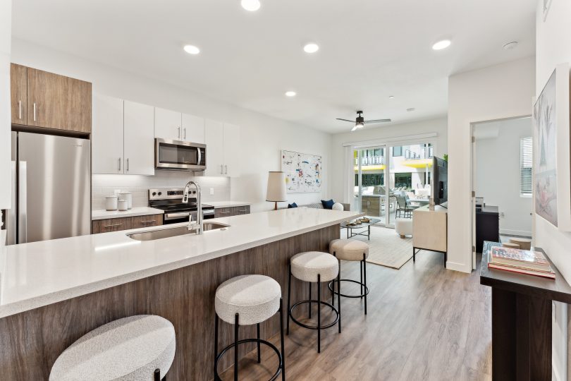a kitchen with white cabinets and stainless steel appliances at The Blue Eastline