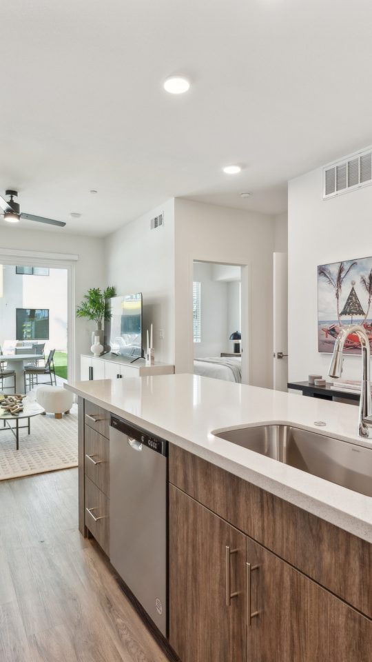 White quartz countertops and a large island inside kitchens at The Blue Eastline