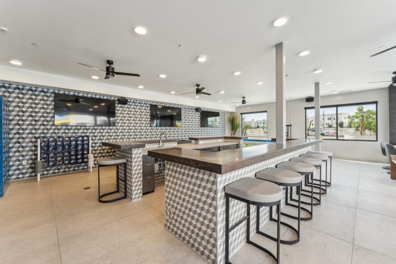 Large community clubhouse with bar and stools at The Blue Eastline
