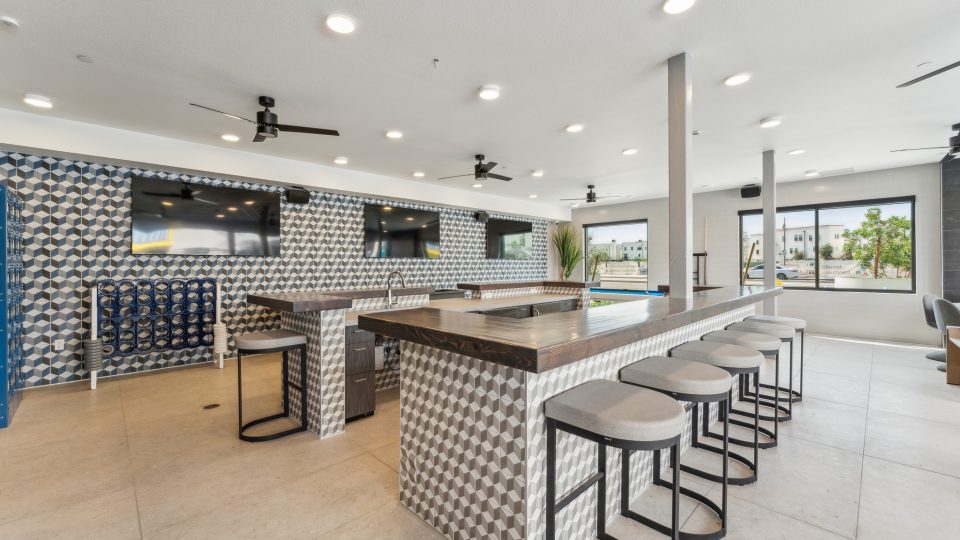 Large community clubhouse with bar and stools at The Blue Eastline