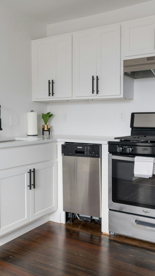 white wooden kitchen cabinet and white microwave oven