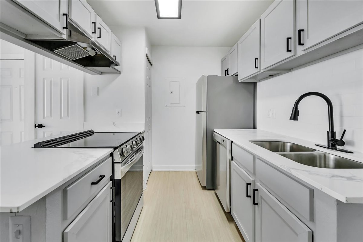 kitchen with stainless steel appliances and white cabinets at The Residences at Bear Creek