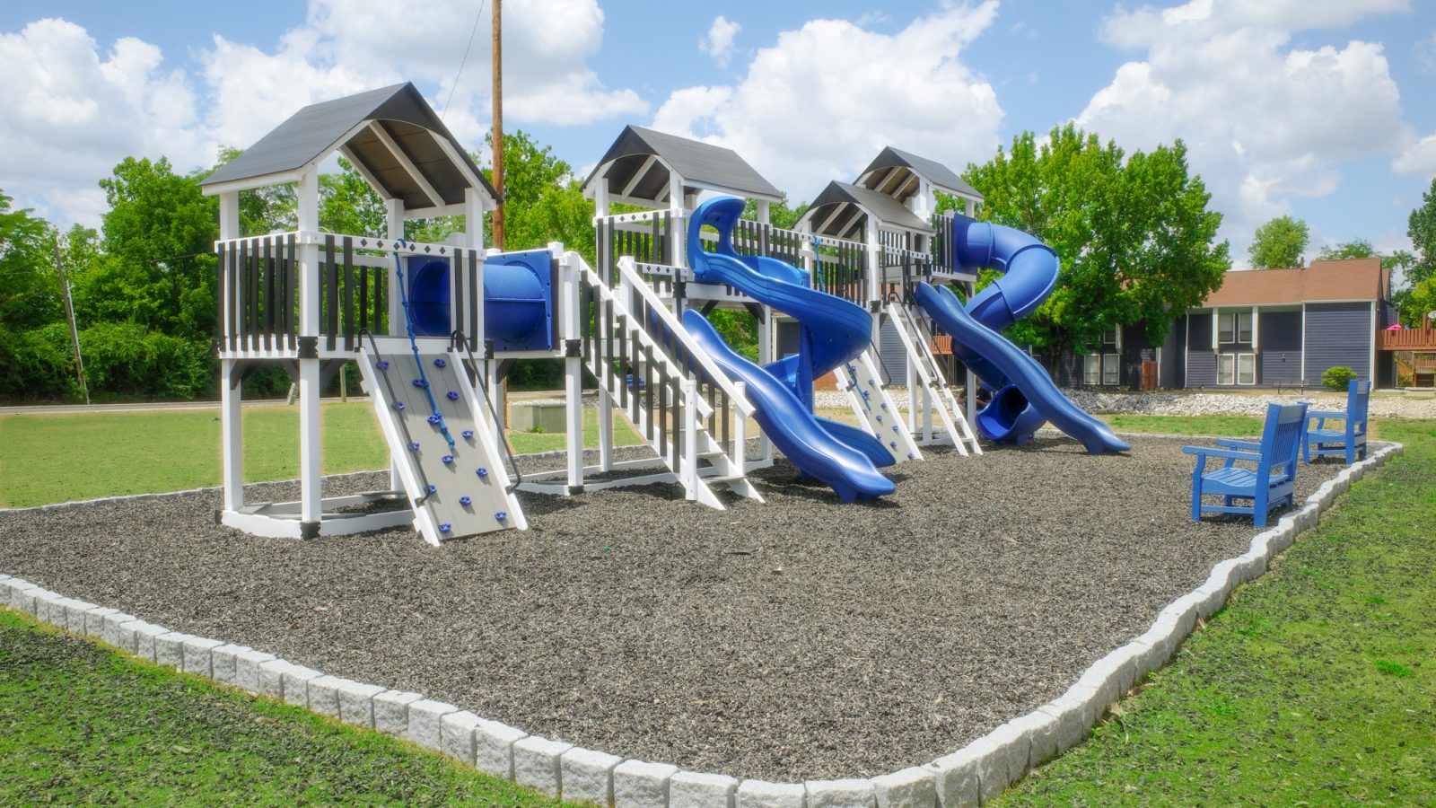 a playground with blue slides and a slide at The Lakeshore Cove