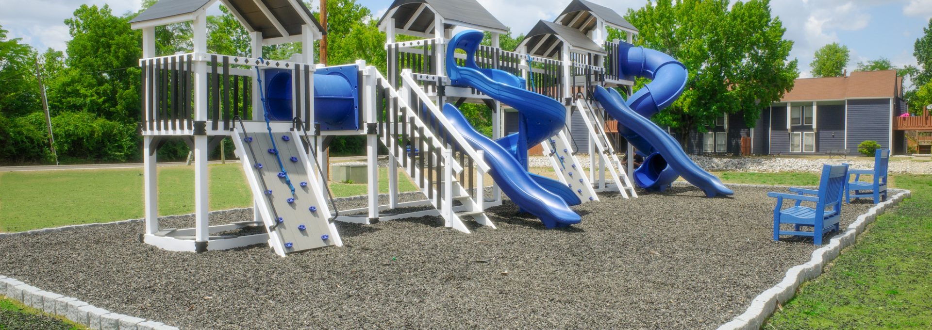a playground with blue slides and a slide at The Lakeshore Cove
