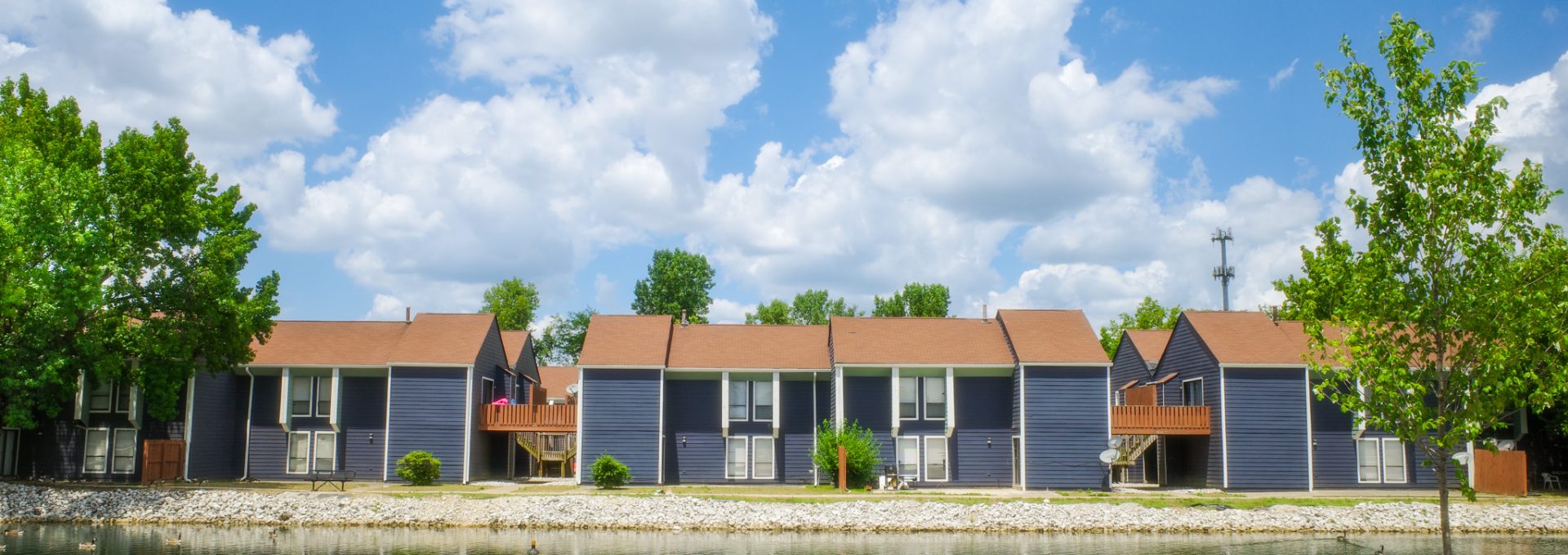 the apartment complex is surrounded by grass and trees at The Lakeshore Cove
