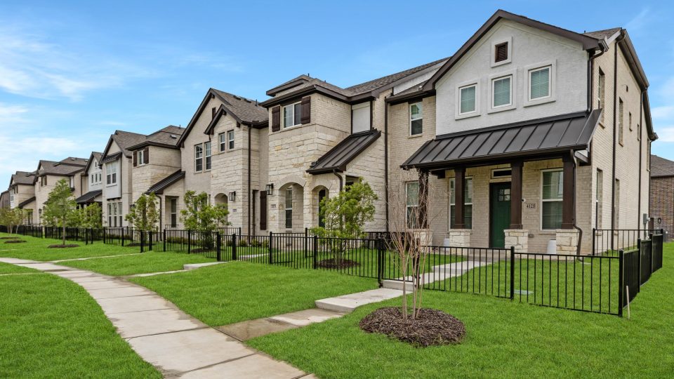 Exterior view of townhomes at The Villas at Bardin's with fences, green grass, and trees out front