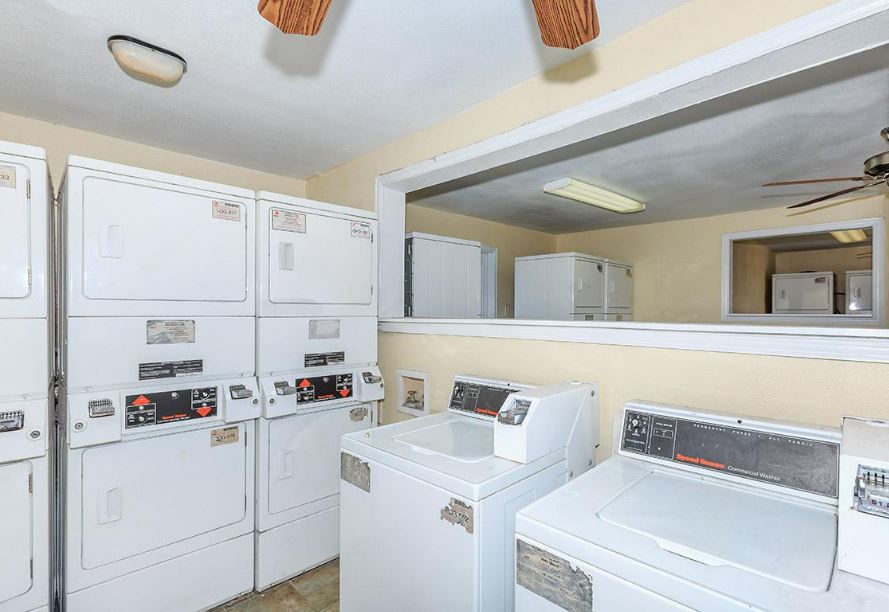 a laundry room with washers and dryers and a ceiling fan at The Cantera Apartment Homes