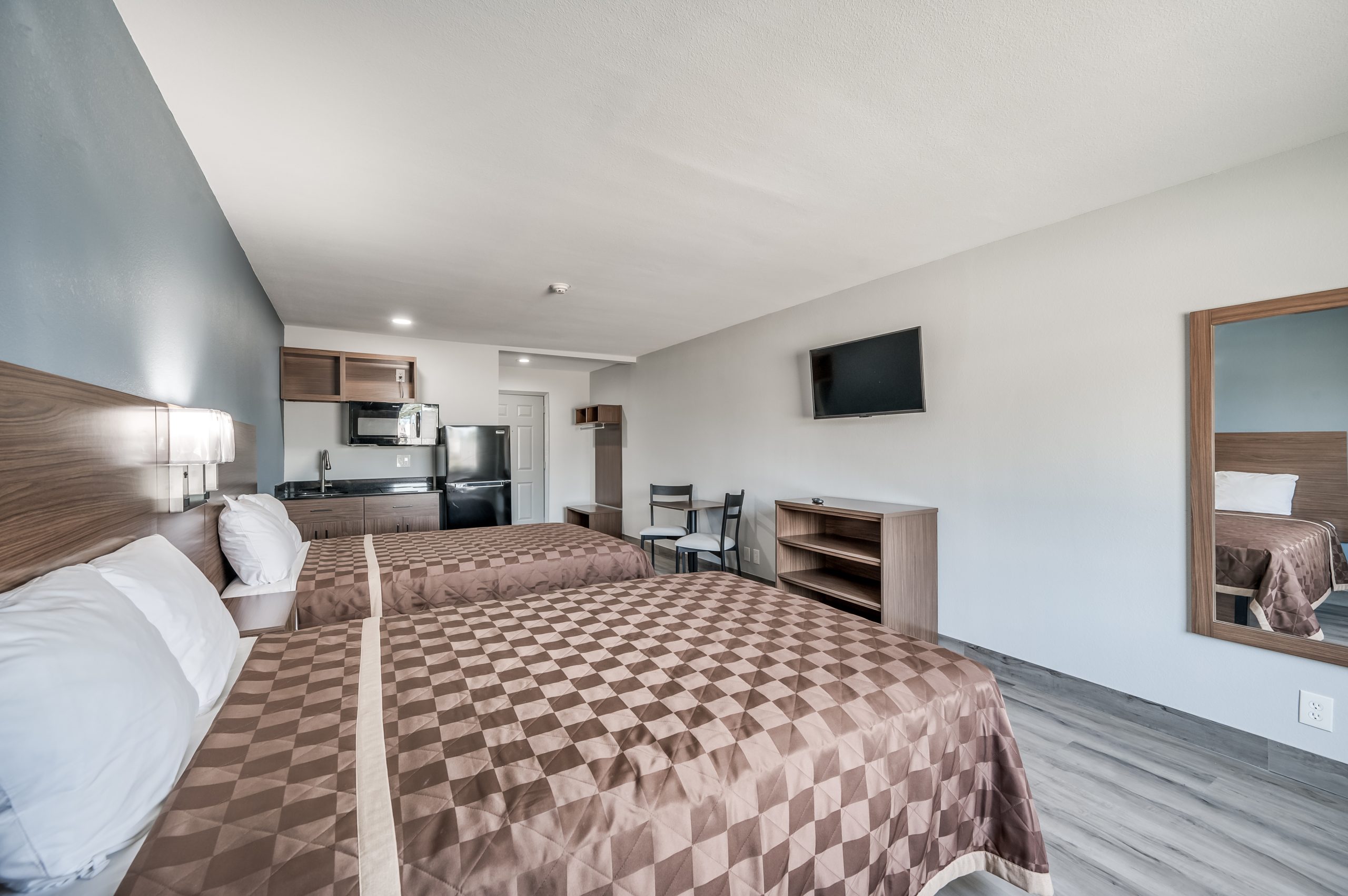 a hotel room with two beds and a television at The Studios At Channelview