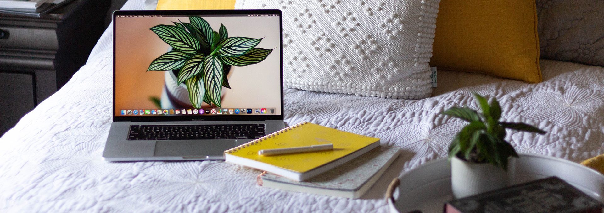 Stock photo of a laptop and journal on a bed
