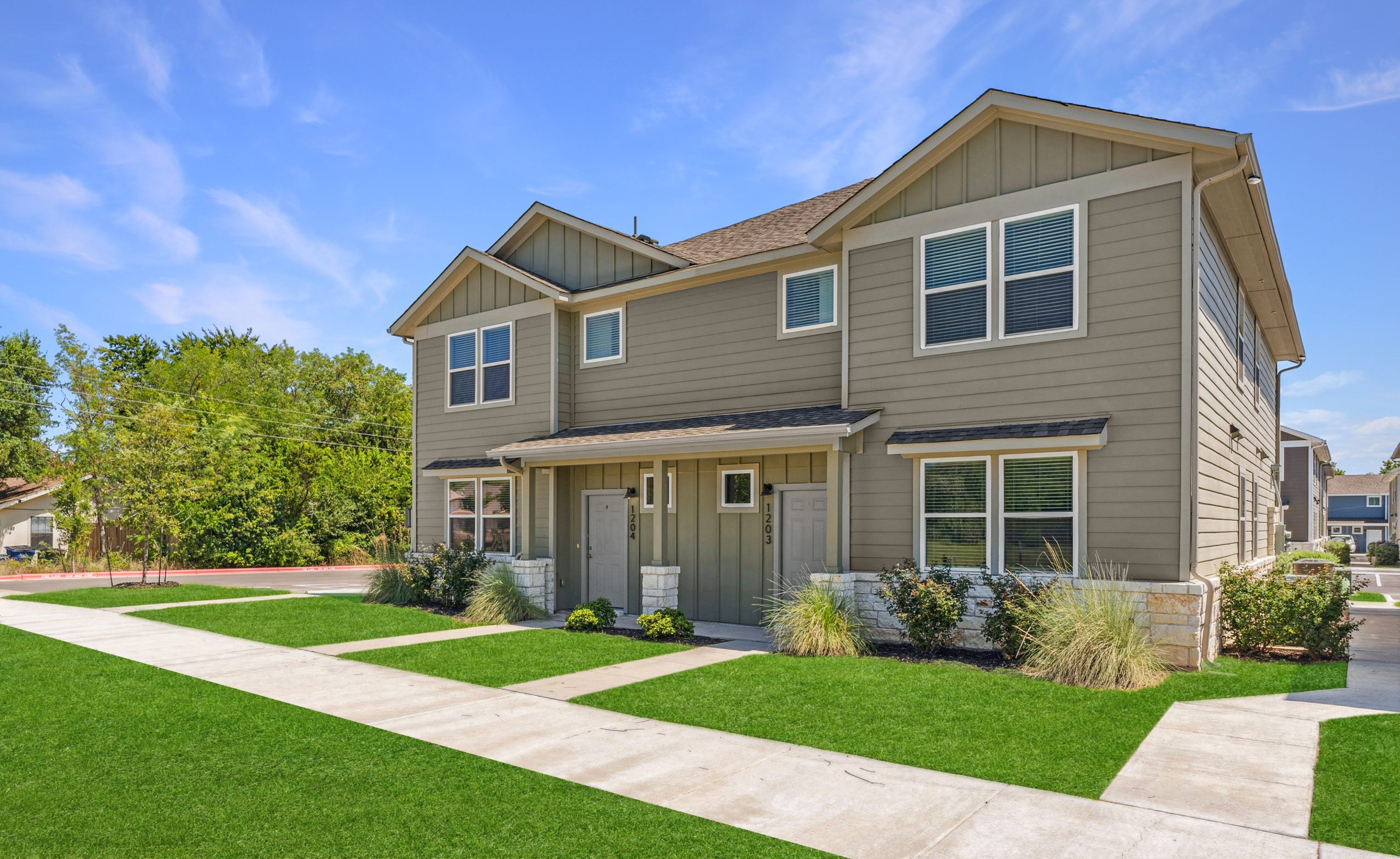 a two story home with grass and a driveway at The Powell