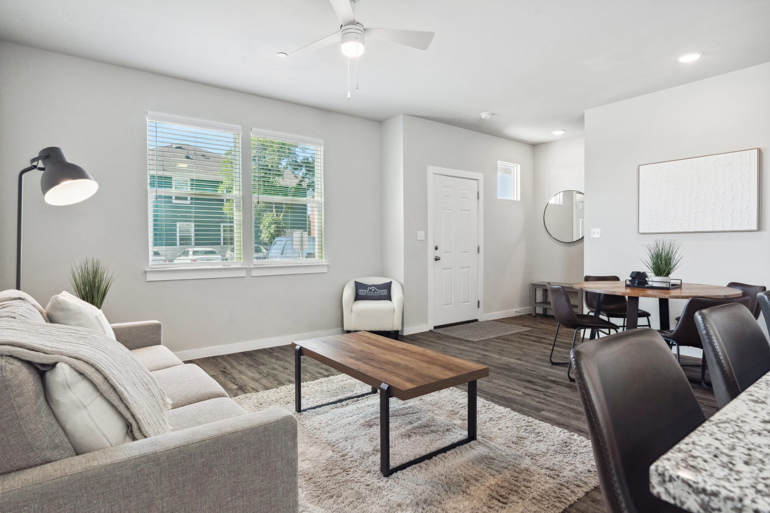 Furnished living room with a couch, coffee table and television inside a model townhome at The Powell
