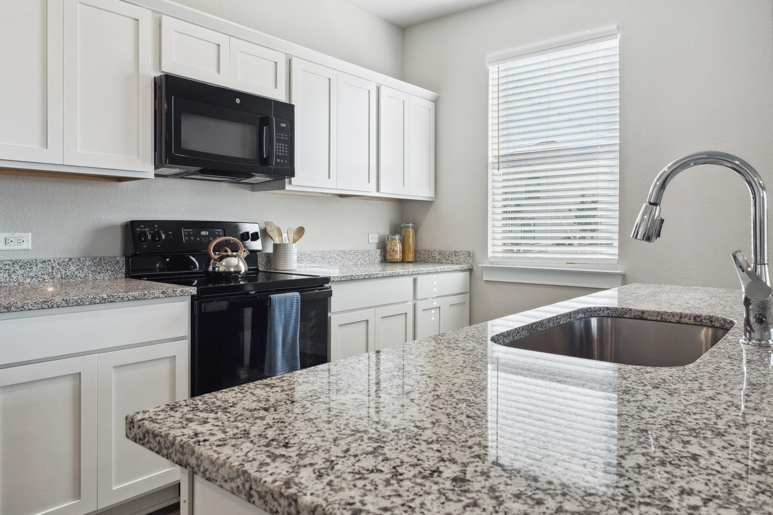 Townhome kitchen with granite counter tops and stainless steel appliances inside homes at The Powell