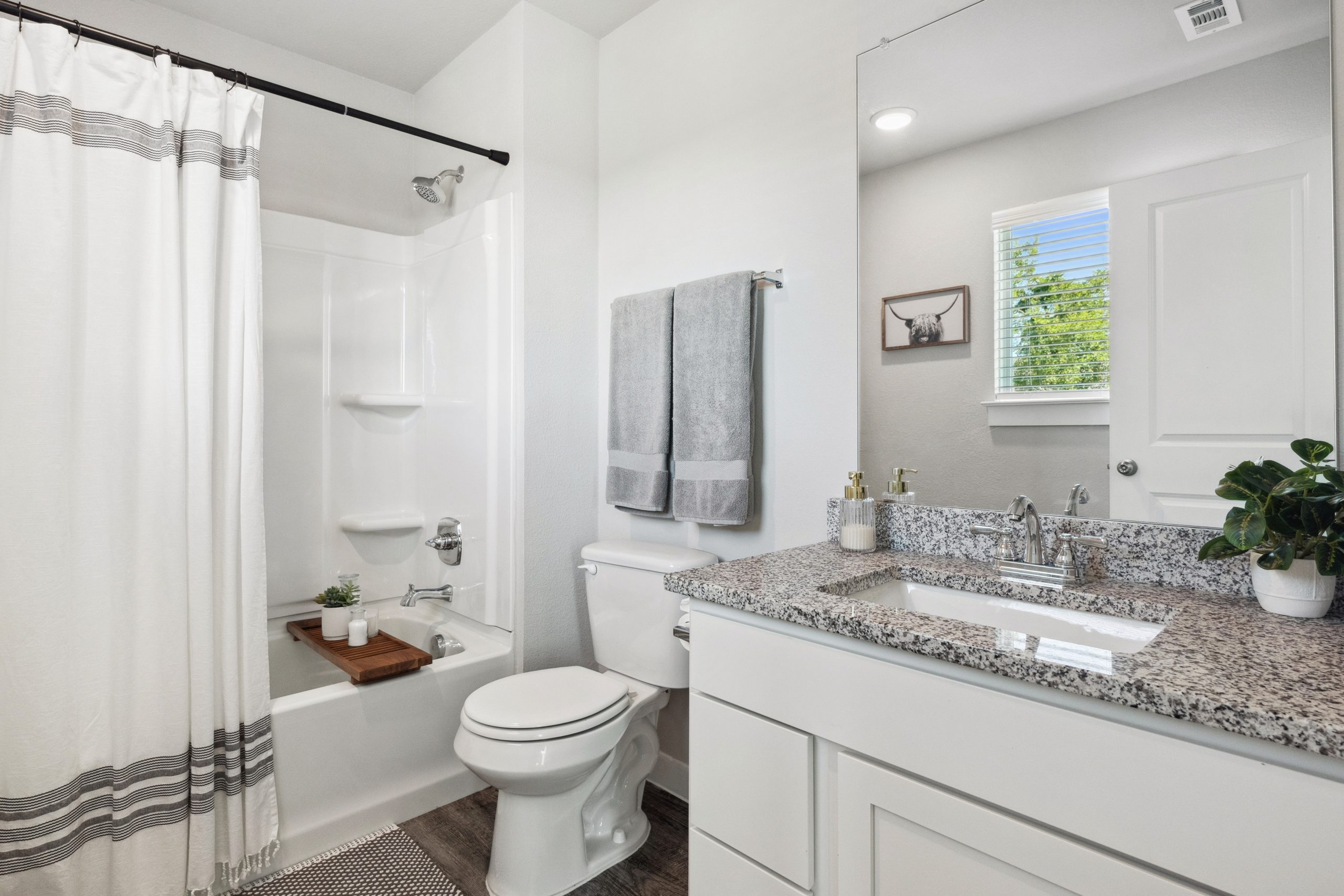a bathroom with white cabinets and a shower at The Powell