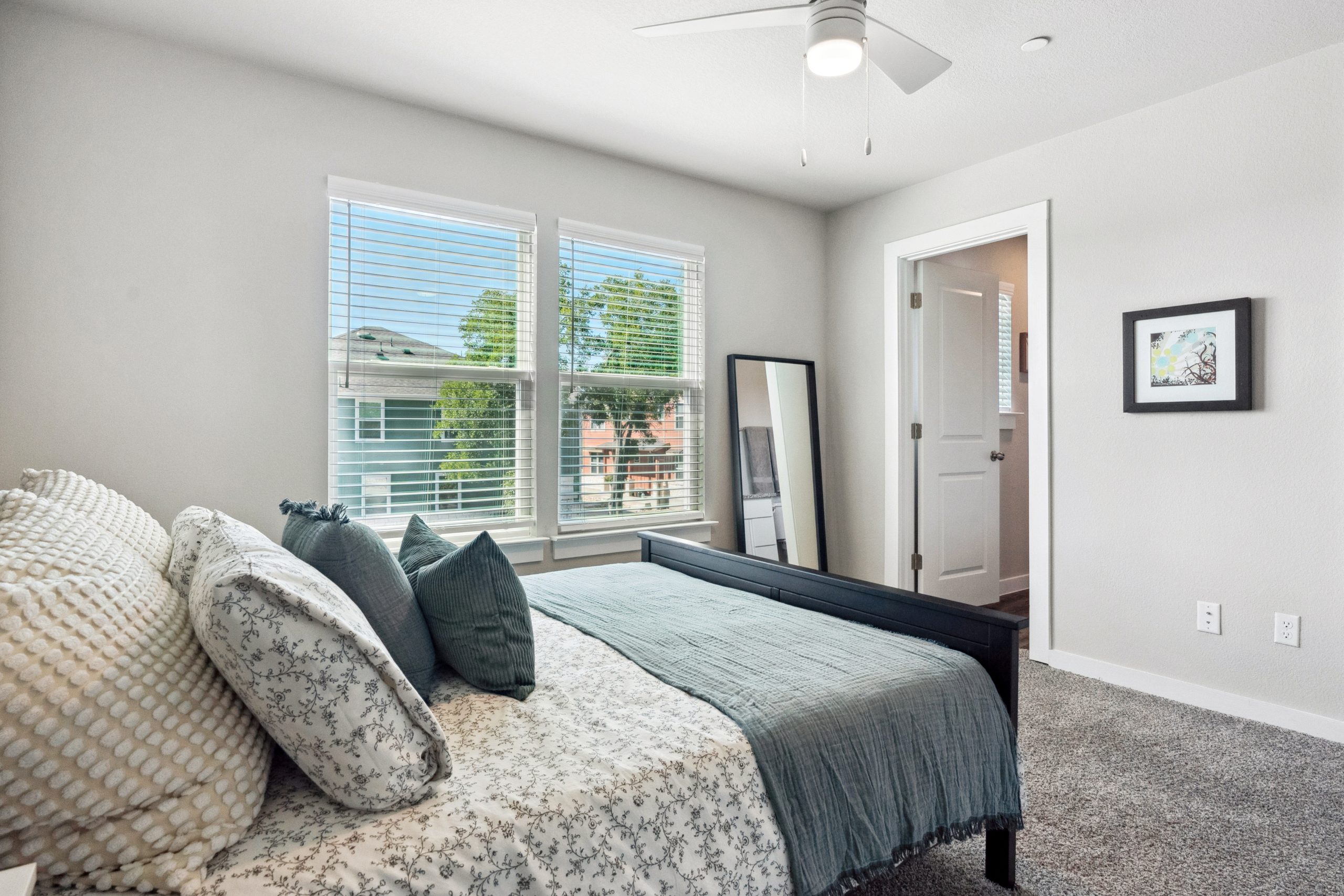 a bedroom with a bed, dresser and ceiling fan at The Powell