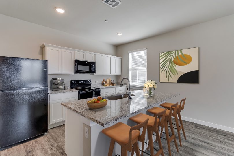 Townhome kitchen with an island and black appliances at The Powell