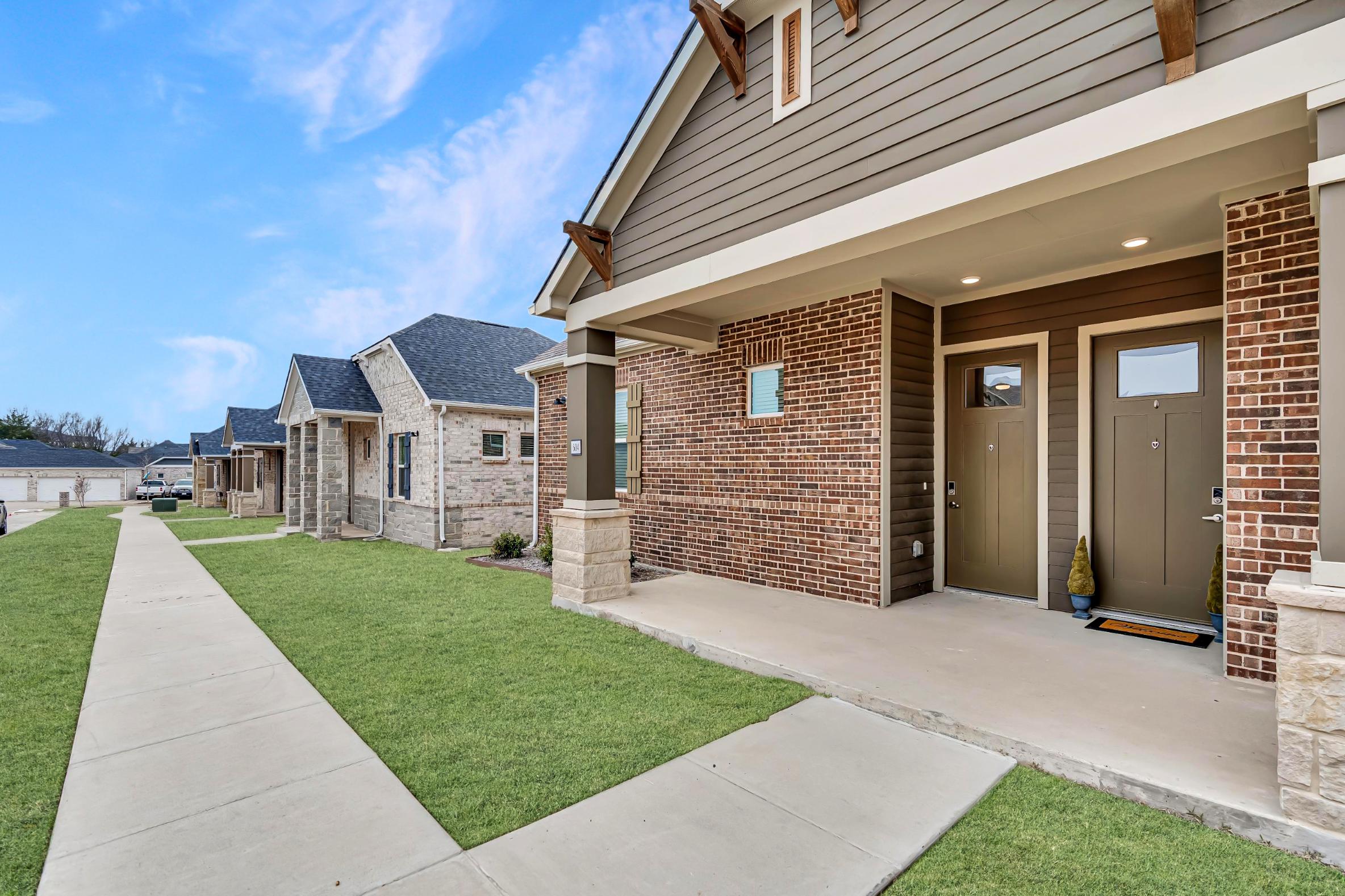 a home with a front porch and grass at The VLux Stoneridge