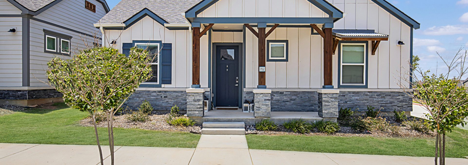 The front entrance of a home and front yard at The VLux Trails