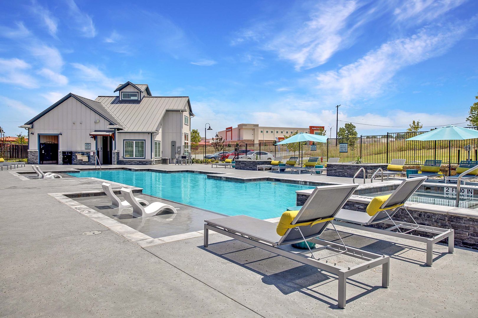 Communtiy pool and hot tub with ample lounge seating at VLux Trails