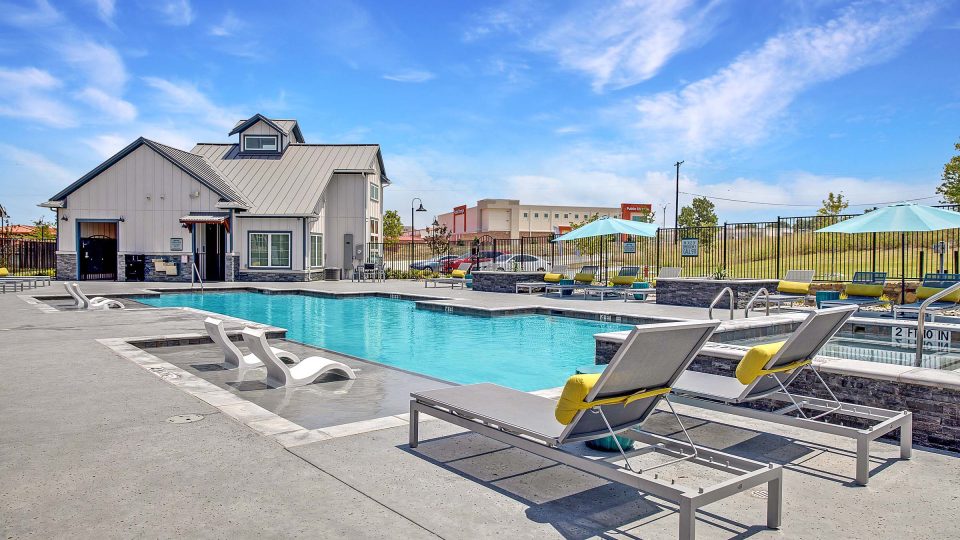 Communtiy pool and hot tub with ample lounge seating at VLux Trails