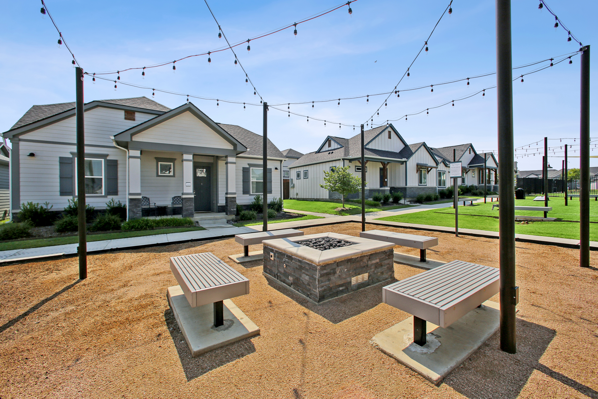Bench seating surrounding a community fire pit at VLux Trails