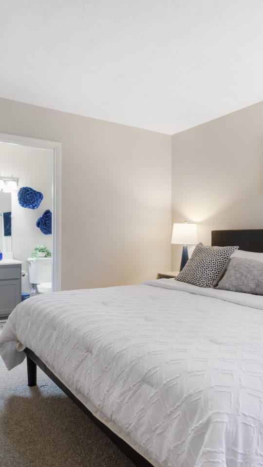 a bedroom with a white bed and a large mirror at The  Wynne