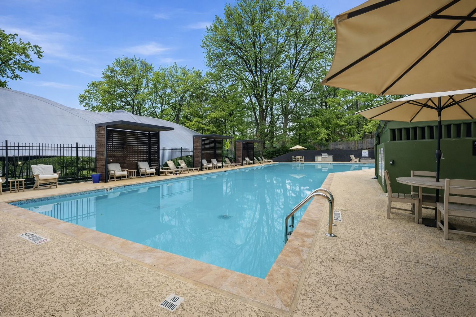 a swimming pool with umbrellas in front of a building