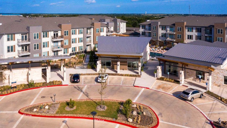 an aerial view of the apartment complex with parking lot at The  Conley