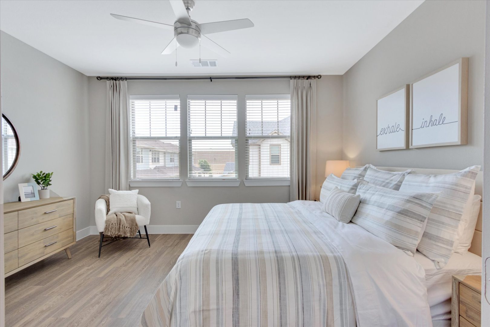 a bedroom with a white bed and hardwood floors at The Town Arlington