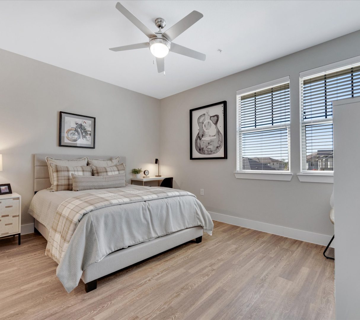 a bedroom with a ceiling fan and hardwood floors at The Town Arlington