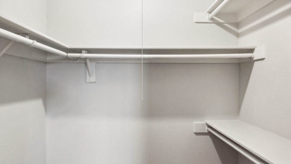Walk-in closet with built-in shelving in a Country Gables apartment home