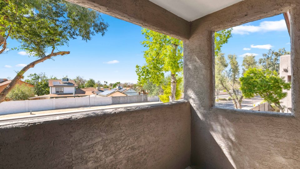 Private covered balcony with neighborhood views at a Country Gables apartment home