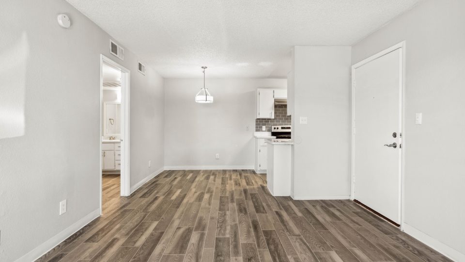 Open-concept living and kitchen area with wood-style flooring at Country Gables