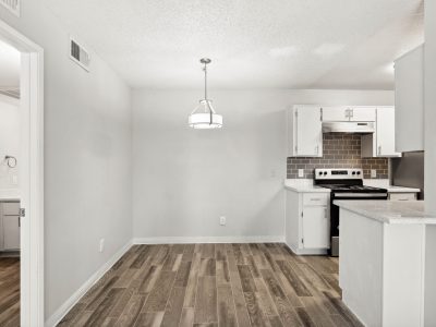 Apartment kitchen with electric range, ample cabinetry, and wood-style flooring at Country Gables