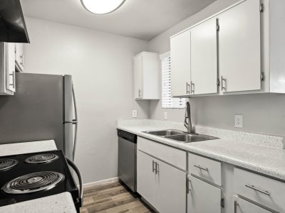 Kitchen featuring a stainless-steel refrigerator, dishwasher, and double basin sink at Country Gables