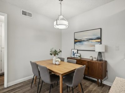Dining area with table, upholstered chairs, and sideboard at Country Gables in Glendale, AZ