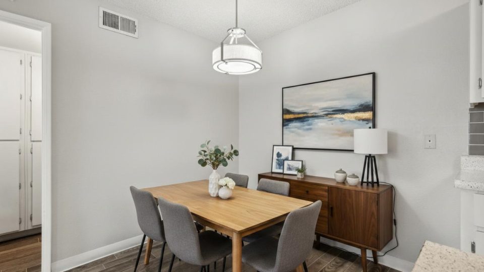 Dining area with table, upholstered chairs, and sideboard at Country Gables in Glendale, AZ
