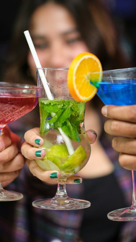 Friends raising glasses for a toast at a happy hour near Country Gables in Glendale, AZ