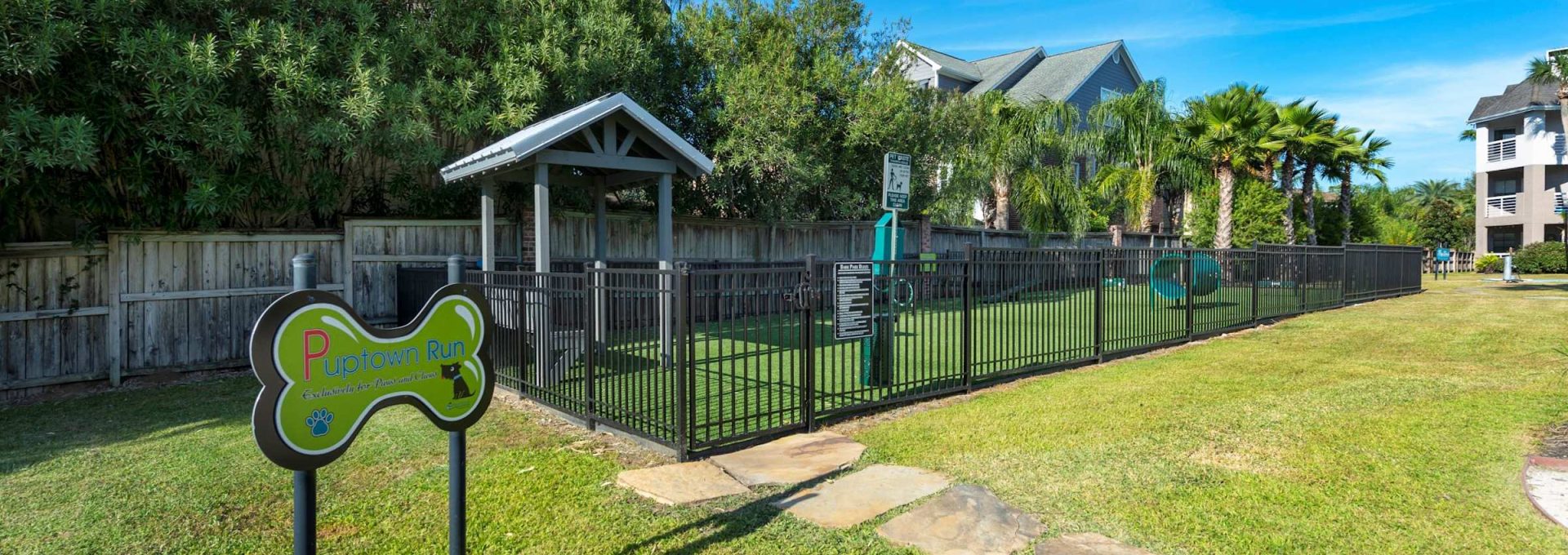 Fenced bark park with agility equipment at Anchor at South Shore in League City, TX
