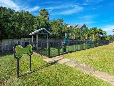 Fenced bark park with agility equipment at Anchor at South Shore in League City, TX