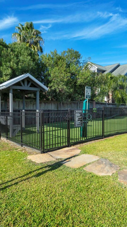 Fenced bark park with agility equipment at Anchor at South Shore in League City, TX