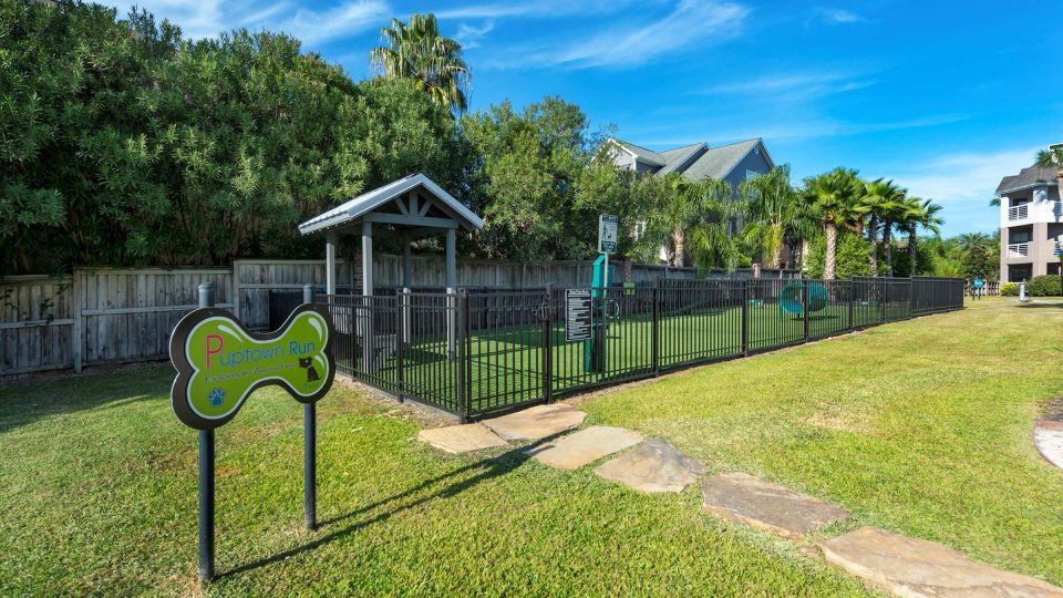 Fenced bark park with agility equipment at Anchor at South Shore in League City, TX