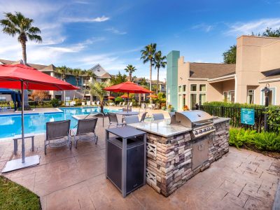Poolside outdoor kitchen and gas grilling station with umbrellas at Anchor at South Shore in League City, TX