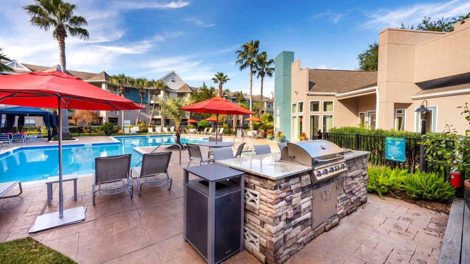 Poolside outdoor kitchen and gas grilling station with umbrellas at Anchor at South Shore in League City, TX