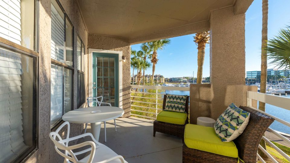 Private apartment balcony with cushioned seating overlooking the marina at Anchor at South Shore in League City, TX