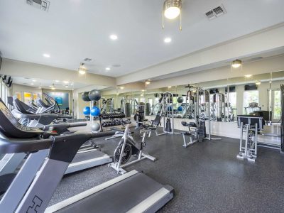 Enhanced 24-hour fitness center with cardio machines and free weights at Anchor at South Shore in League City, TX