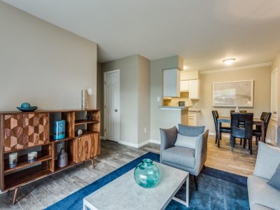 Open living and dining area with media console and wood-style flooring at Clear Creek Landing in Houston, TX