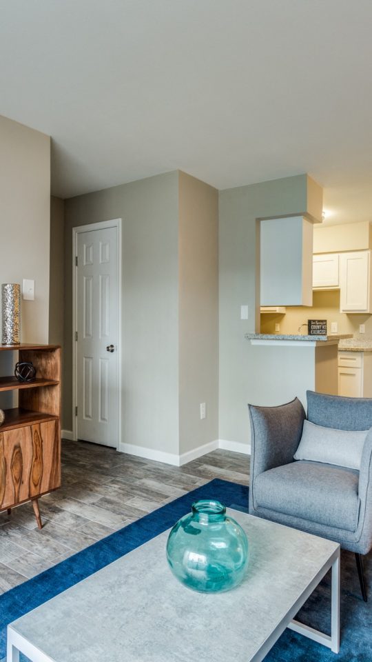 Open living and dining area with media console and wood-style flooring at Clear Creek Landing in Houston, TX